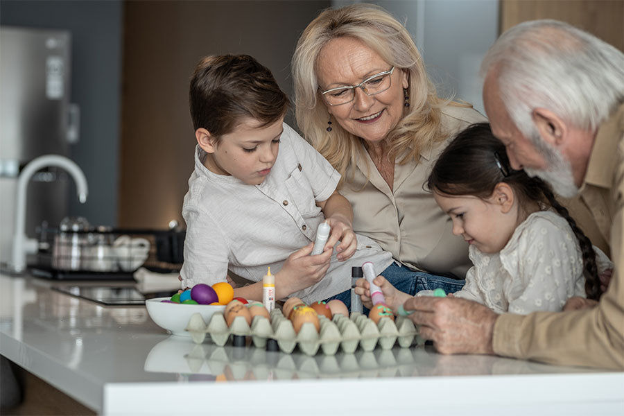 Opa en oma met kleinkinderen eieren schilderen