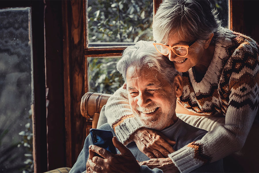Ouder stel knuffelend bij het raam
